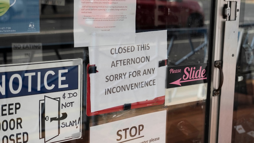 Shop closed sign in Hobart storefront.