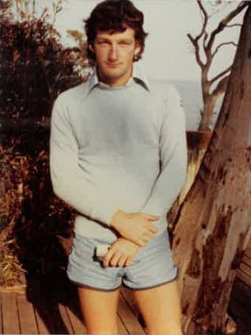 young man standing in sweater and shorts