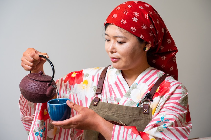 Woman wearing traditional Japanese clothing preparing miso soup