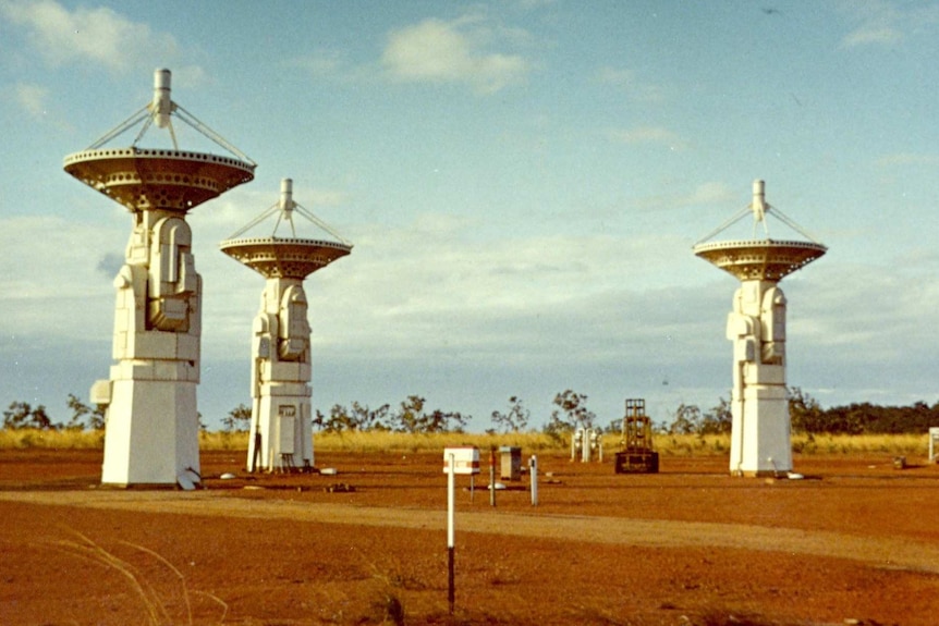 Three satellite trackers pointed up to the sky in an old photograph from 1967.