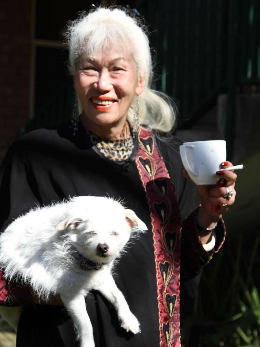 Retired transgender performer Ayesha holds her puppy