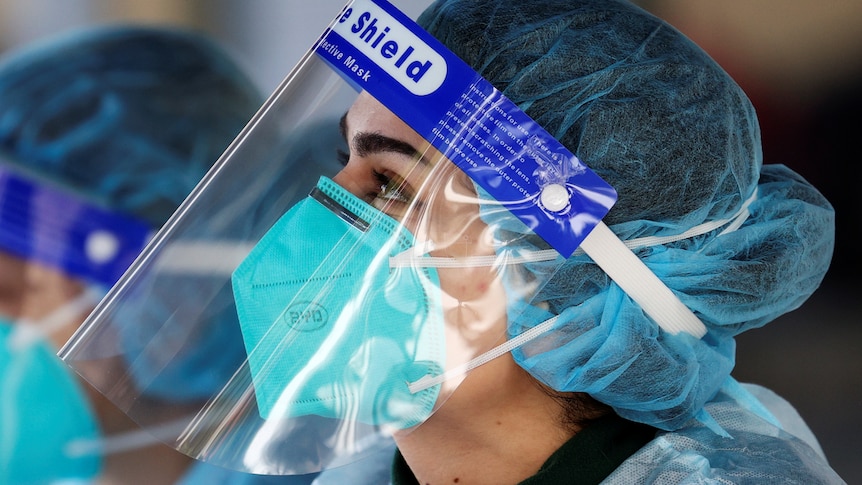 A medical personnel is pictured wearing a BYD Care N95 particulate respirator mask and a face shield.