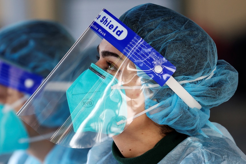 A medical staff member is pictured wearing a BYD Care N95 particle mask and a face shield.