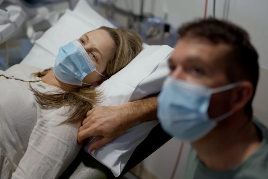 A woman and a man at the hospital looking at an ultrasound screen (not in shot).