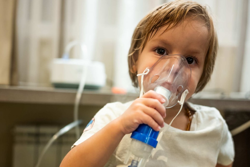 A child wearing a nebuliser for asthma treatment