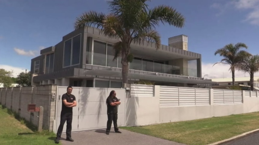 Two men stand outside ACDC drummer Phil Rudd's house