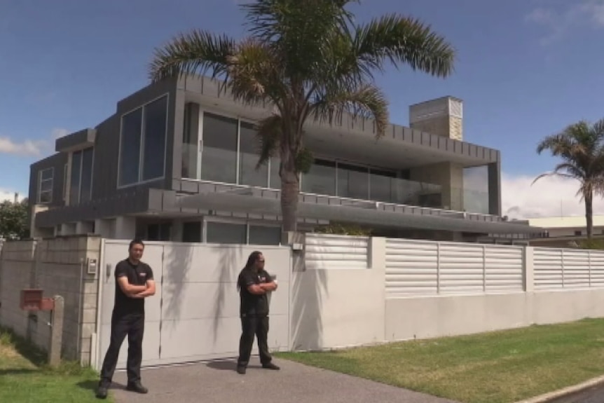 Two men stand outside ACDC drummer Phil Rudd's house