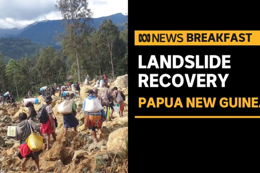 Landslide Recovery, Papua New Guinea: Villagers carry bags as they cross the rubble.