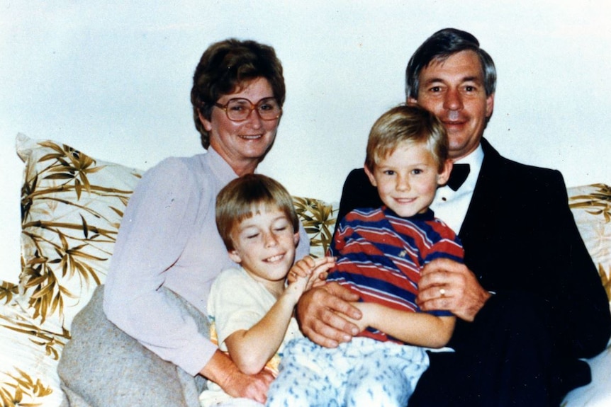 Ben Cox as a child with his father David, mother Patricia and his older brother Andrew sit together on a couch.