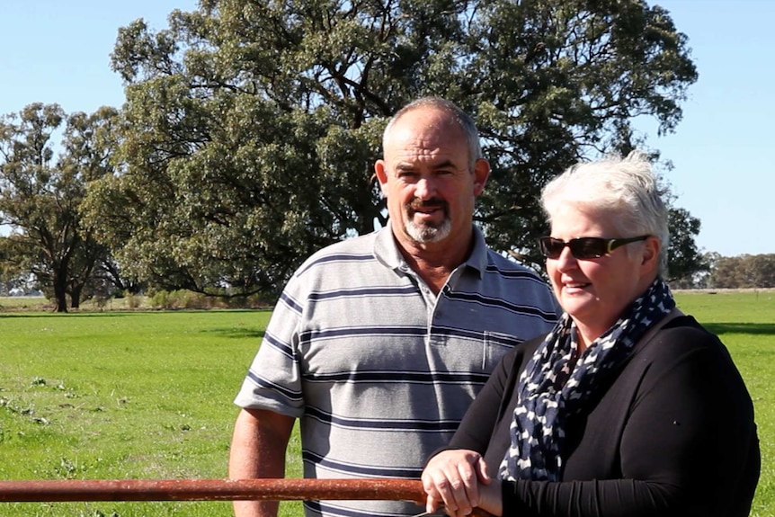 Bridget and Tim Goulding lean on a gate at their dairy farm in northern Victoria