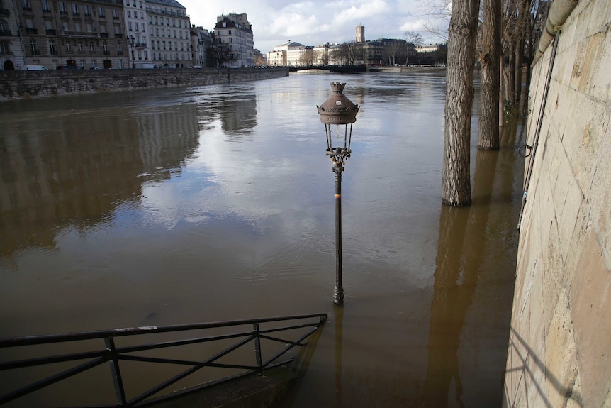 A street lamp and stairs are engulfed by floodwaters in Paris.