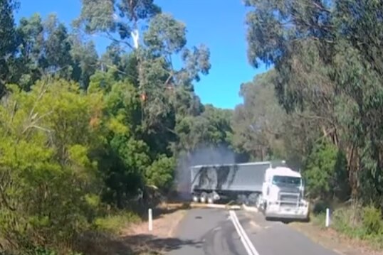 A semi-trailer hits a tree branch