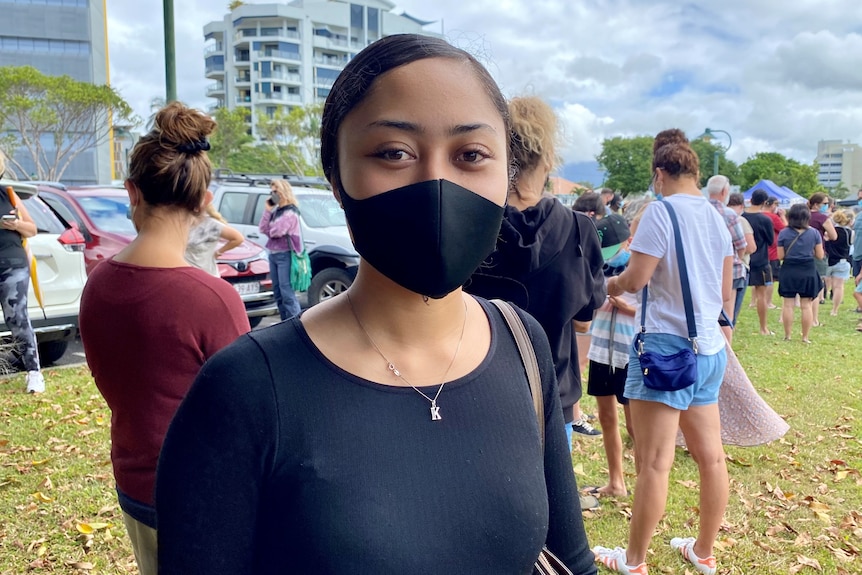 A young woman stands in a COVID testing queue