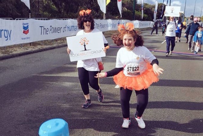 A girl and a woman run towards the finishing line in the City to Surf.