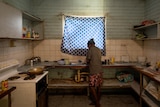 Donnas Rogers stands inside her kitchen at the sink.