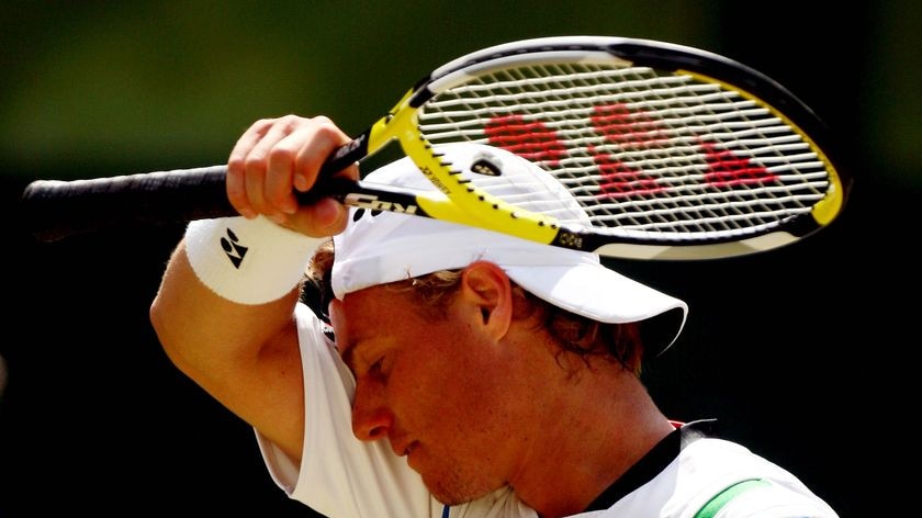 Lleyton Hewitt wipes his face during the men's singles round four match against Roger Federer
