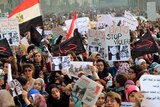 Egyptians hold signs during a protest in downtown Cairo to denounce the military's attacks on women