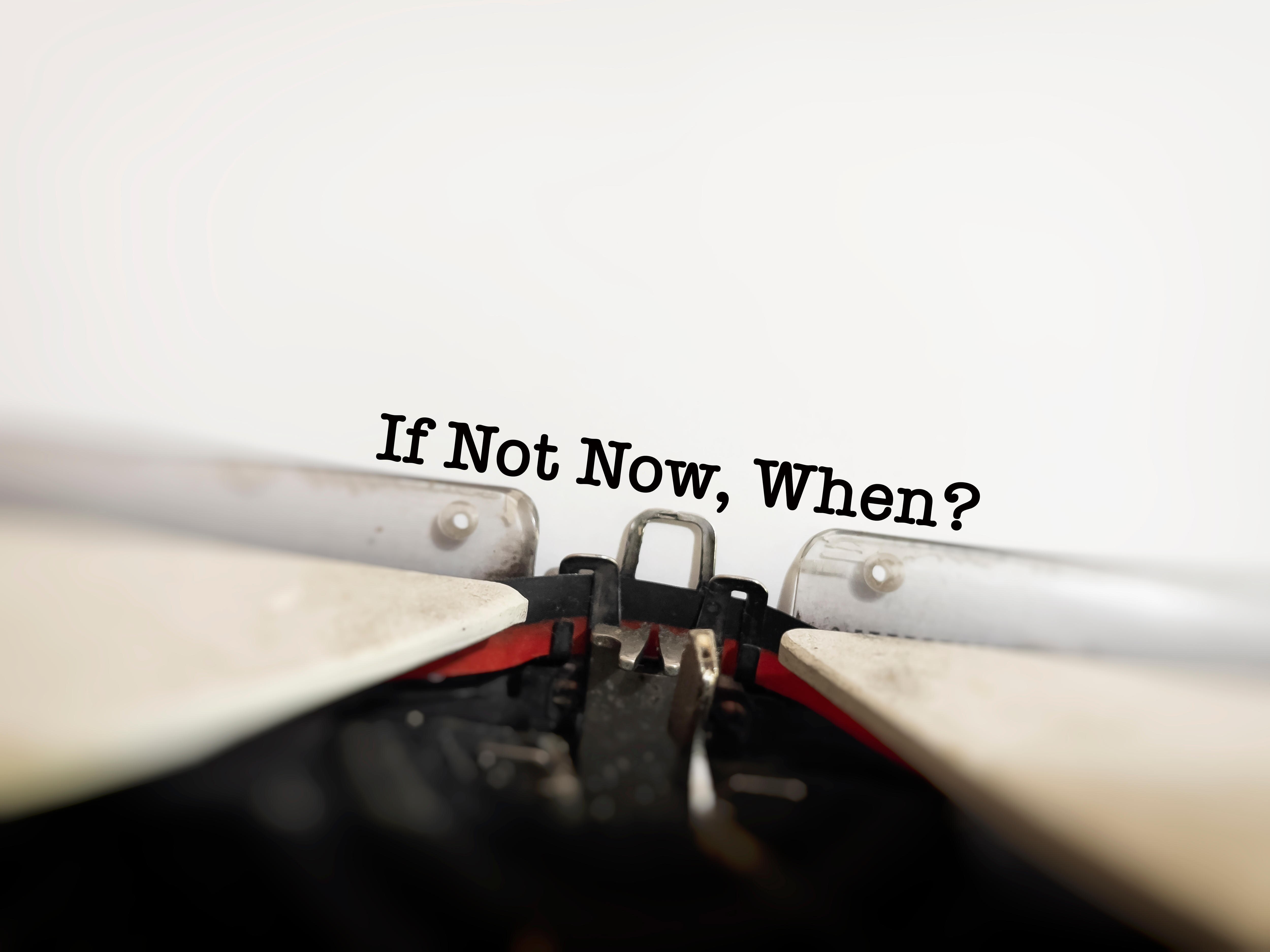 A typewriter with words written: If Not Now, When?