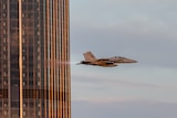 Jet flies close to city building