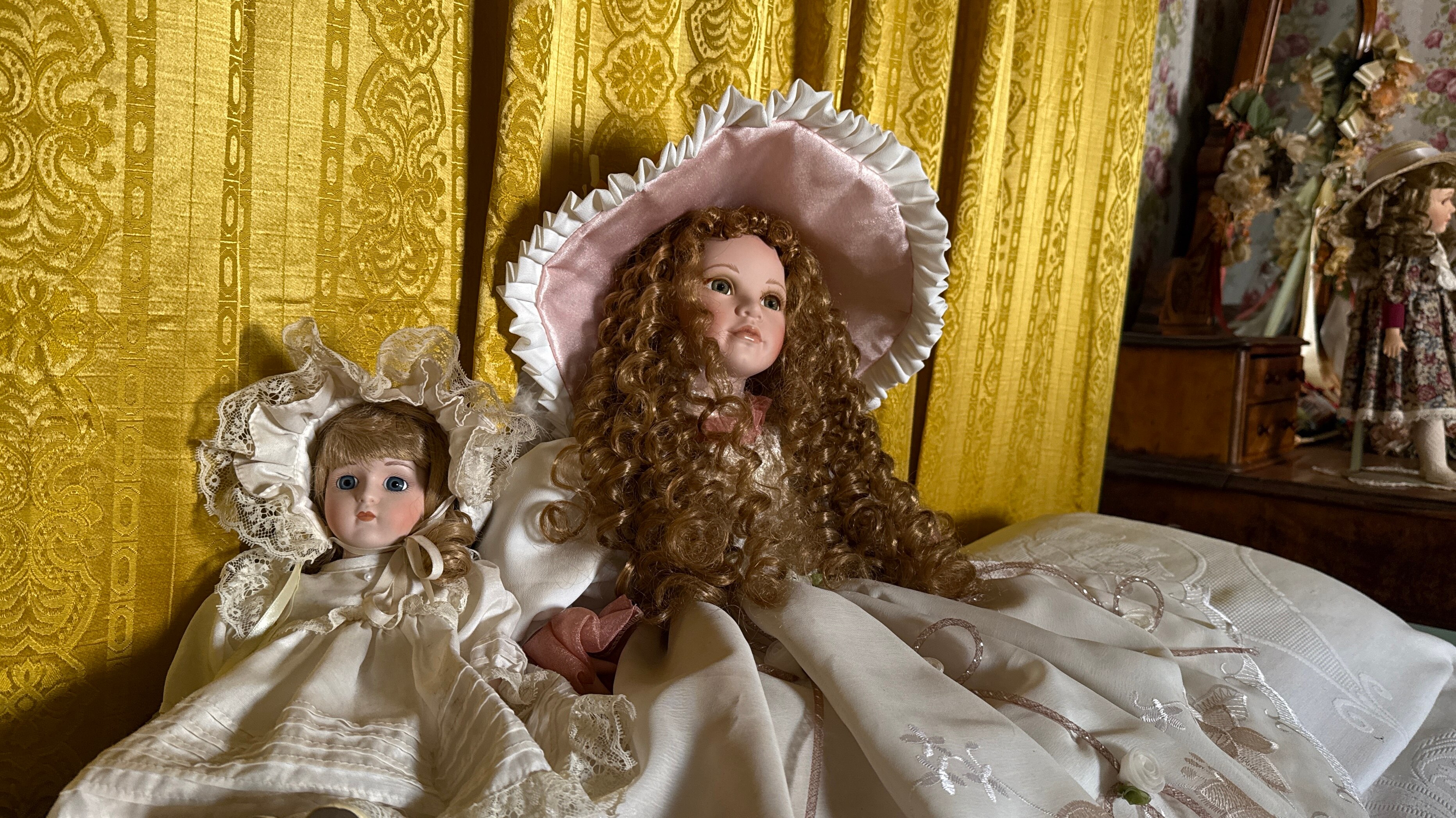 duas bonecas de porcelana com chapéus e vestidos brancos