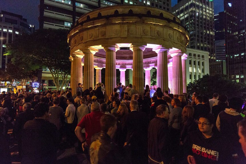 People line up to lay a wreath at the Shrine of Remembrance at Brisbane's Anzac Square.