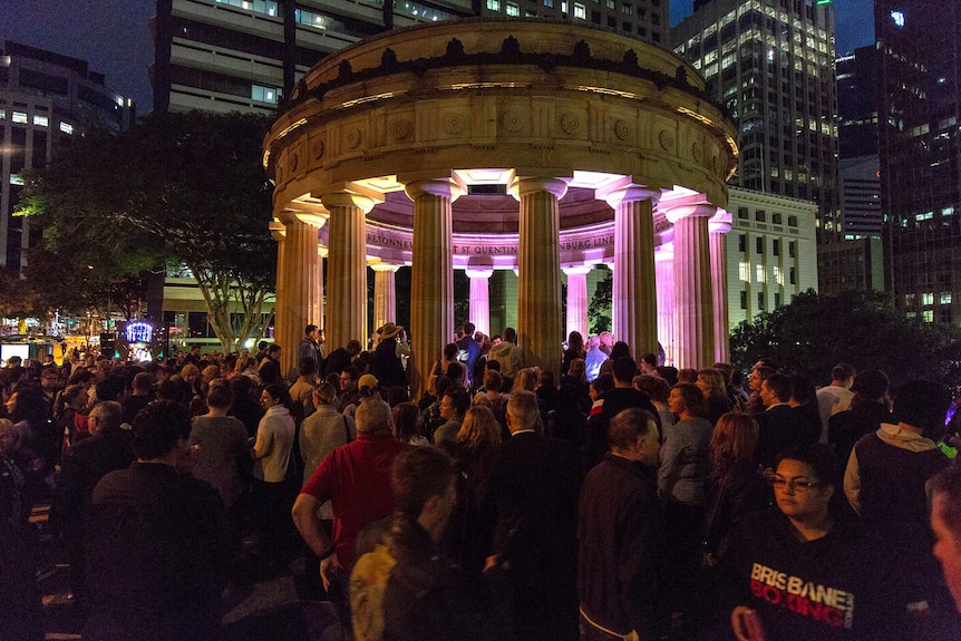 People line up to lay a wreath at the Shrine of Remembrance at Brisbane's Anzac Square.