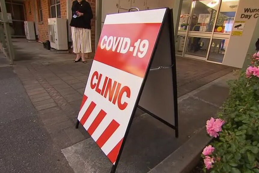 A red and white A-frame sign with the words COVID-19 CLINIC