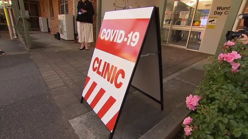 A red and white A-frame sign with the words COVID-19 CLINIC