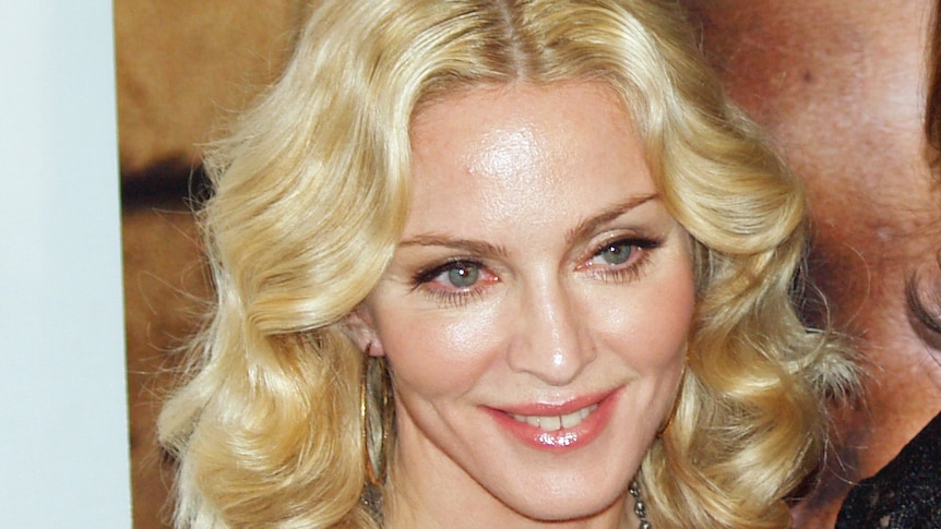 A well-lit photorgraph of the singer Madonna looking away from camera at a film premiere.