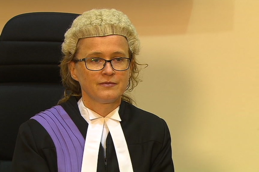 A judge sits in legal attire.