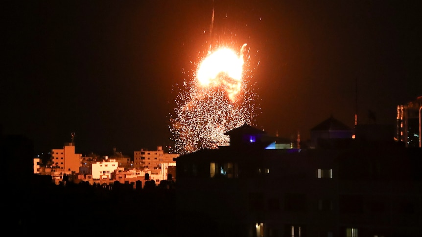 A fireball rises above a building in Gaza City during Israeli air strikes.