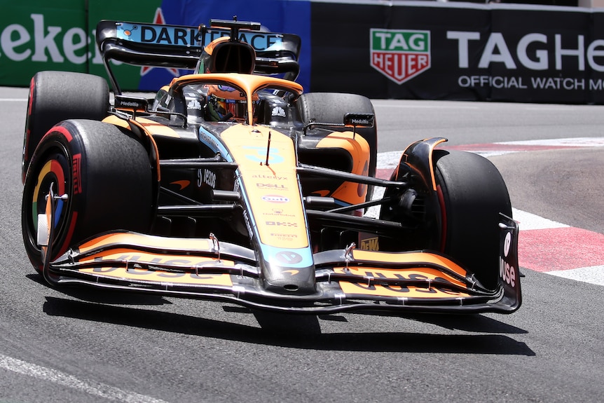 Orange F1 car drives through a tight corner.