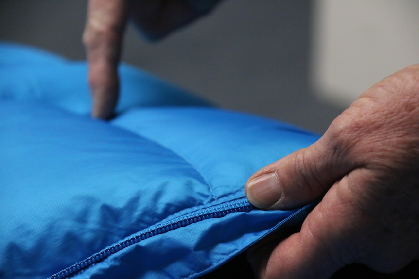 Woman's hands pointing out the virtues of a good puffer jacket.