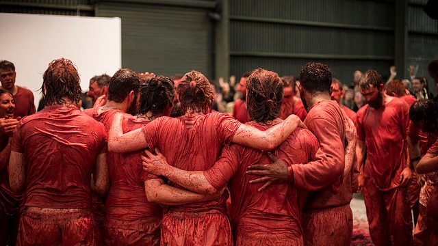Blood-soaked performers embrace in a huddle at Hermann Nitsch's Hobart 150.Action show.