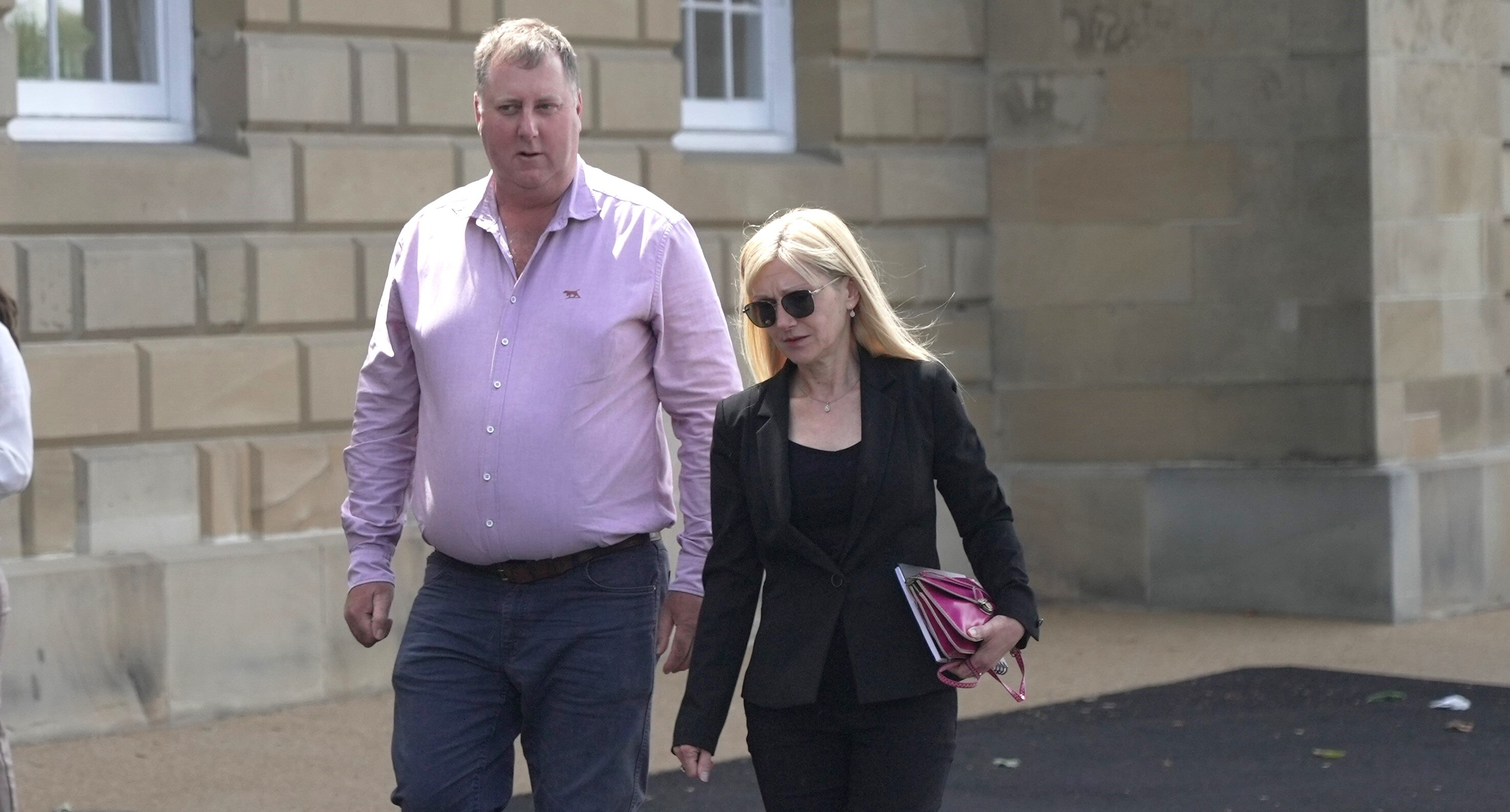 John Tucker and Lara Alexander walk to press conference.
