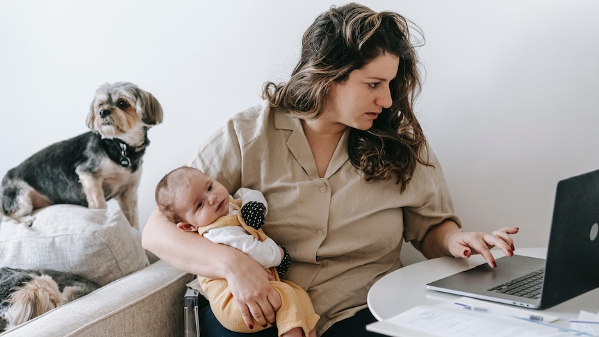 Mother uses PC while holding baby 1