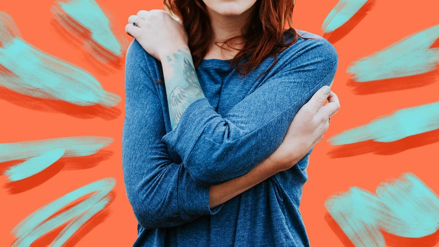 Close up of woman with arms wrapped around herself feeling anxious about coronavirus