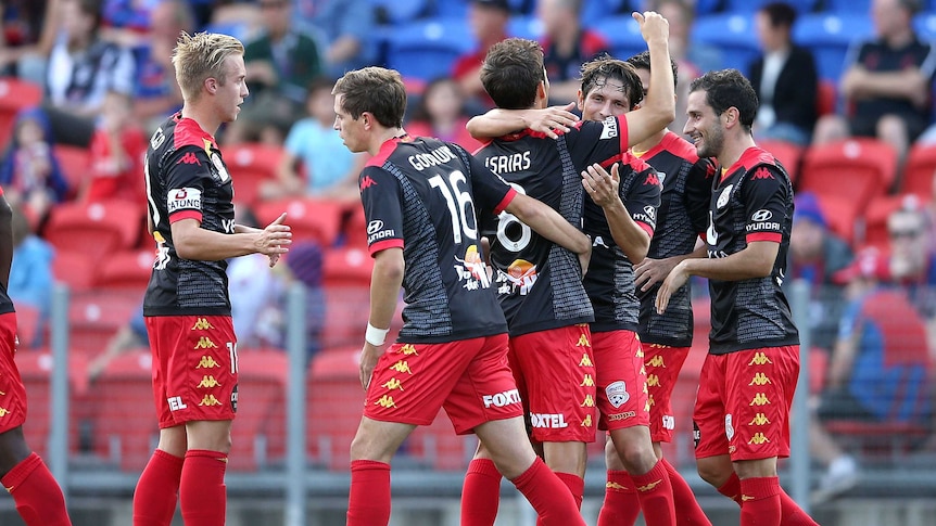 Adelaide United team mates celebrate a goal