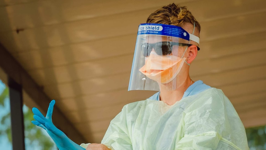 A worker at the Howard Springs quarantine centre dons personal protective equipment.