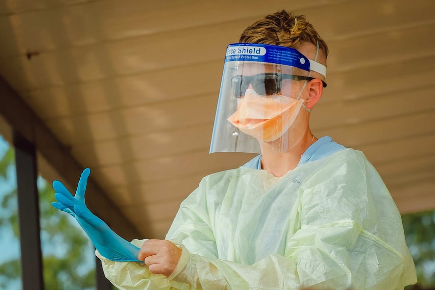 A worker at the Howard Springs quarantine centre dons personal protective equipment.