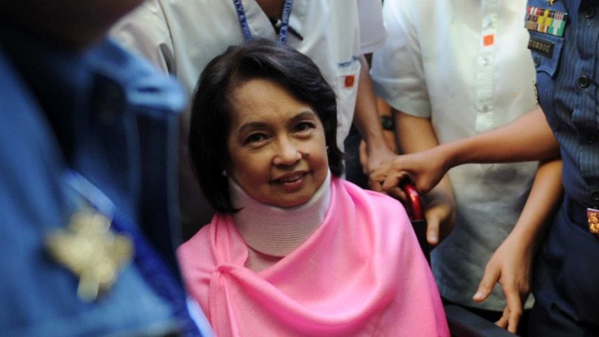 Gloria Arroyo arrives at court in a wheelchair and neck brace