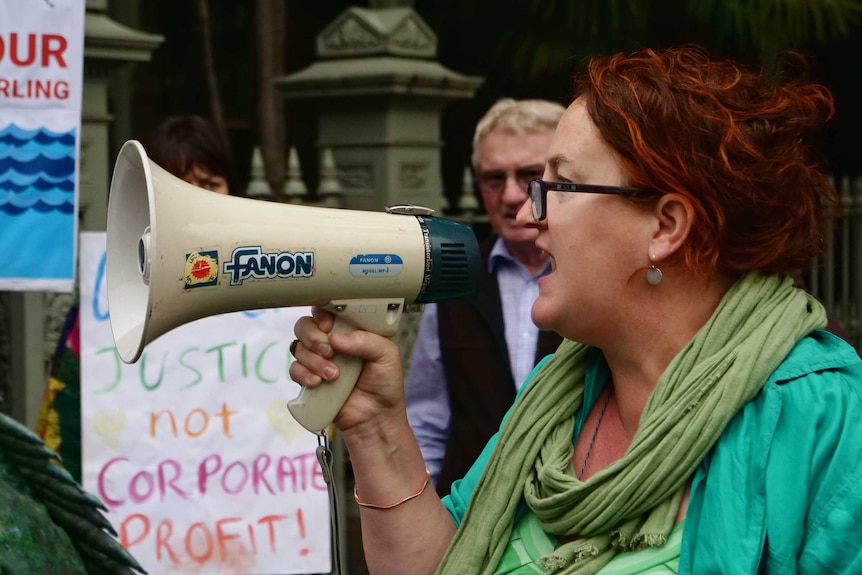 A woman uses a megaphone in a protest.