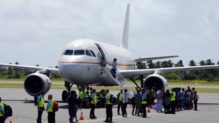 Group of 157 Sri Lankan asylum seekers boarding plane from Cocos Islands to Derby, Western Australia