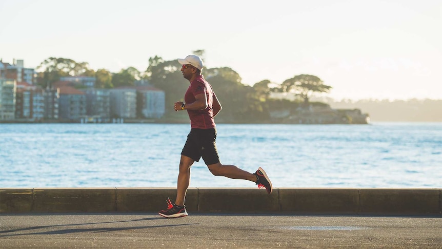 A man runs past a body of water.