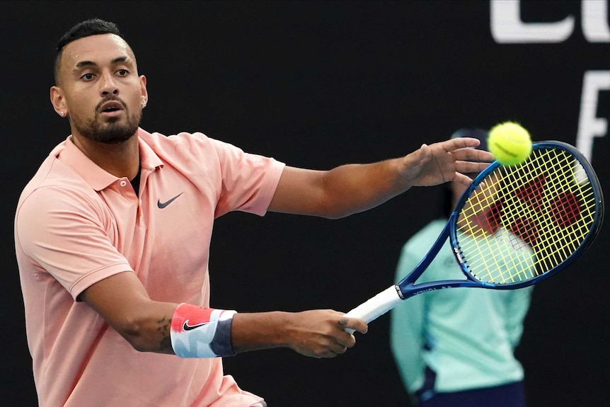 A male tennis player watches the ball after hitting a forehand at the Australian Open.