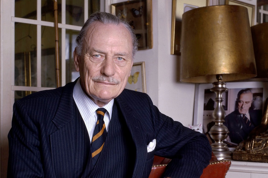 UK parliamentarian Enoch Powell reclines on a couch.