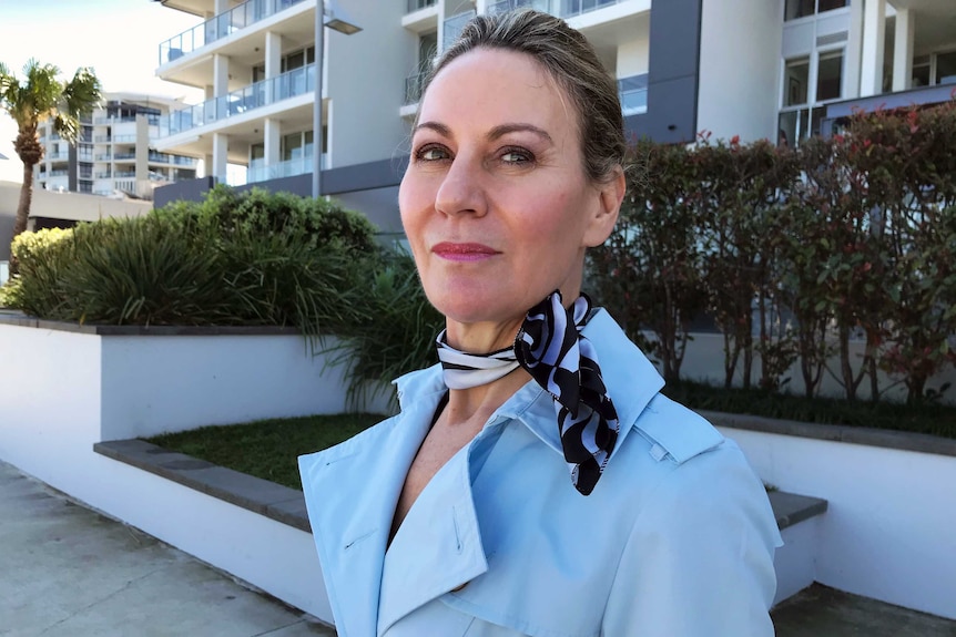 MCU of former air hostess Catherine Pearson standing outside an apartment block.