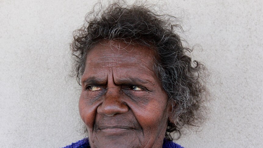 An Aboriginal woman looks slightly away from the camera, head and shoulders portrait.