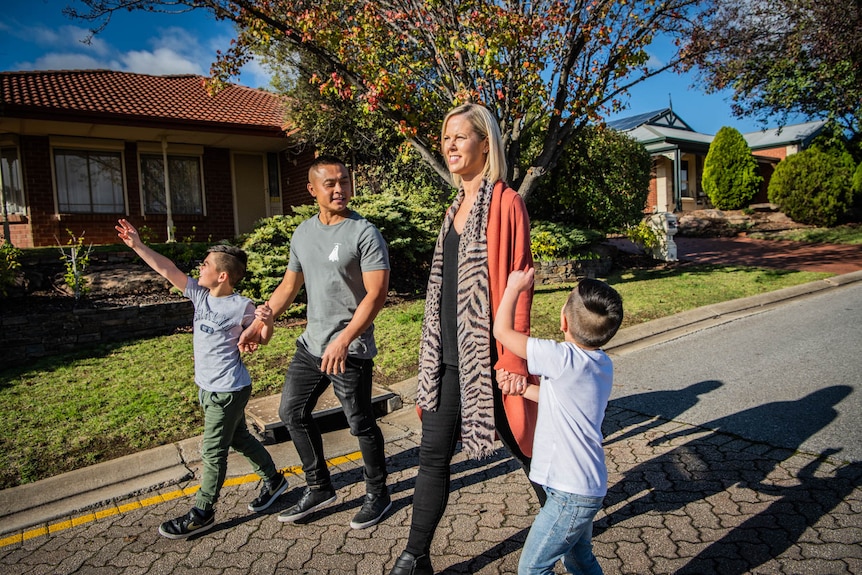 A young couple waliking with their two children.