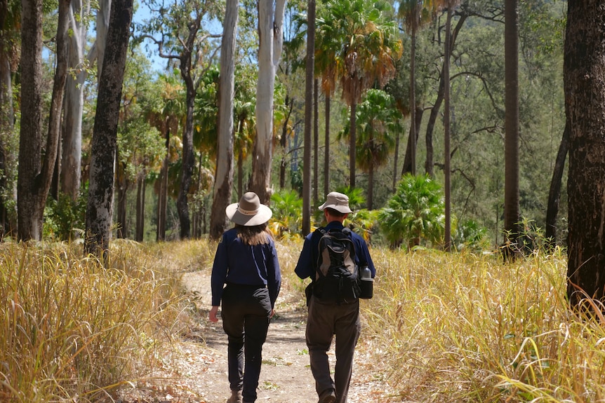 Simon and Michelle walking a path, bush and trees on either side.